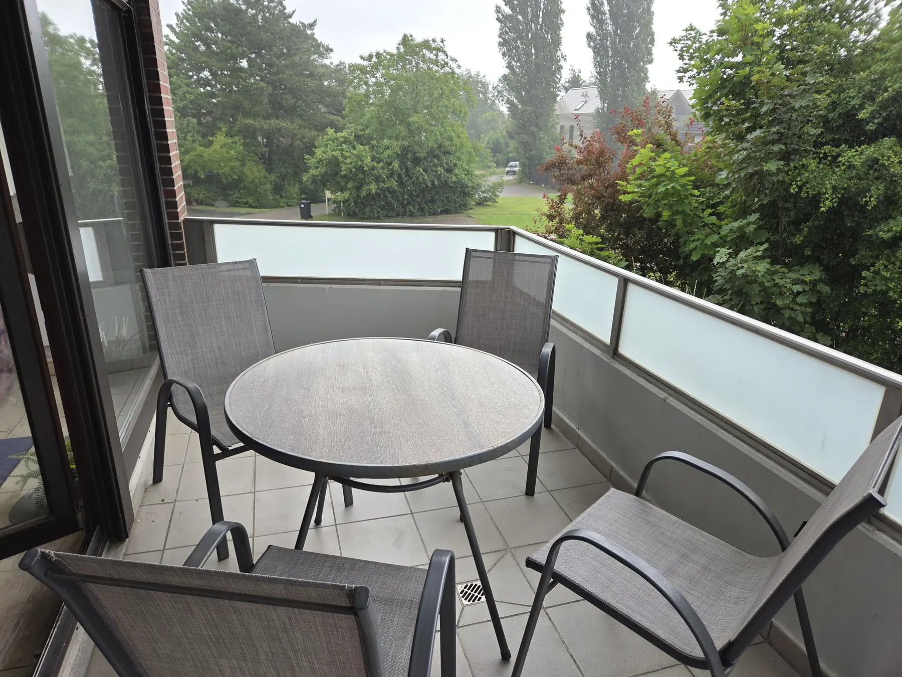 Balkon mit Tisch, Stühlen und Blick ins Grüne